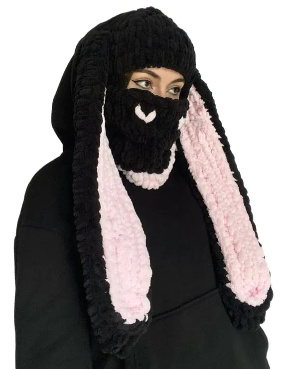 Black knitted bunny hat with pink ears on a white background